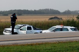 A white pick up truck with its doors open after being forced off the road by police in Saskatchewan, Canada