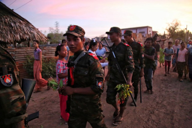 Anti-coup fighters are presented with flowers by locals in a town in the Sagaing region, north central Myanmar.