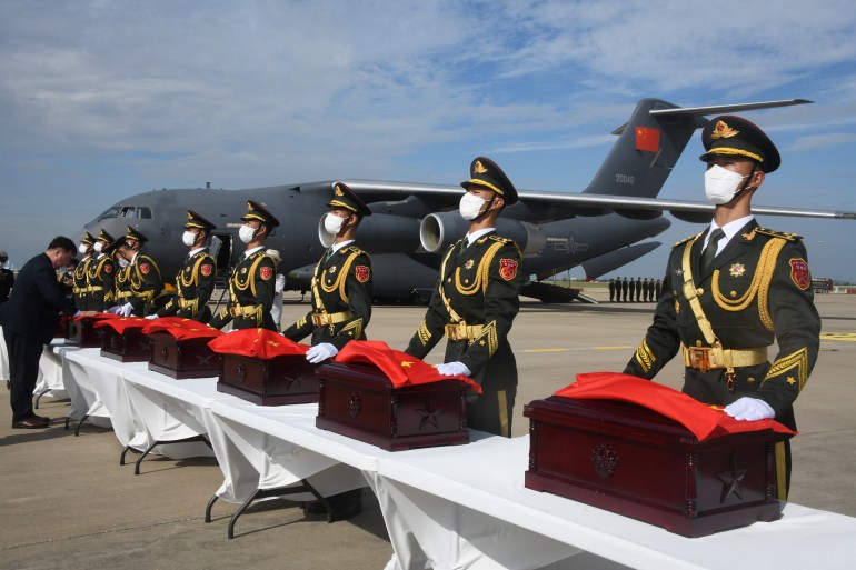 Soldiers carry caskets containing the remains of Chinese soldiers during a handing over ceremony at the Incheon International Airport in Incheon on September 16, 2022 [Song Kyung-Seok/AFP]