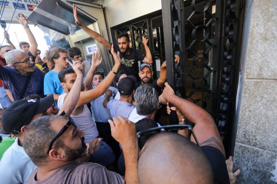 People gather outside the Blom Bank branch in the capital Beirut's Tariq al-Jdideh neighbourhood on September 16, 2022, to express their support to a depositor, who stormed the bank demanding to withdraw his frozen savings.