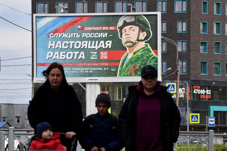 A billboard promoting contract army service with an image of a serviceman and the slogan reading "Serving Russia is a real job" sits in Saint Petersburg.