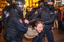 Police officers detain a man following calls to protest against partial mobilisation announced by Russian president in Moscow [File: Alexander Nemenov/AFP]