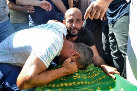 Mourners react by the body of one of the victims who drowned in the shipwreck.