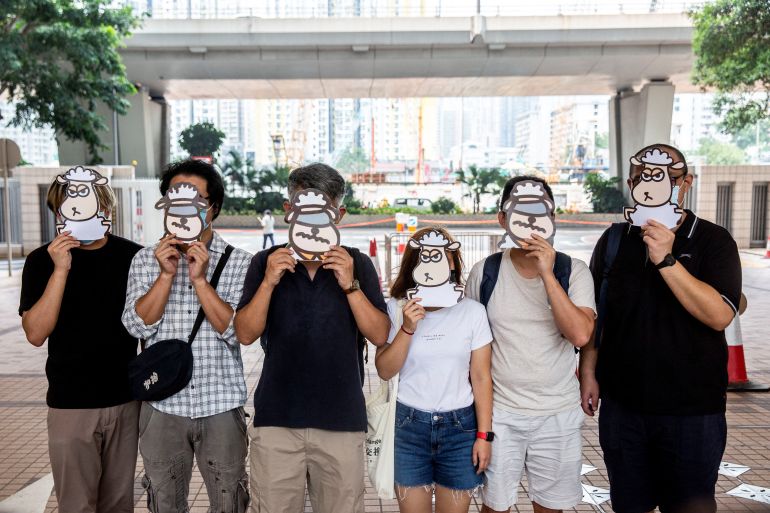 Six supporters of the speech therapists outside court during their trial holding cartoon sheep masks over their faces.