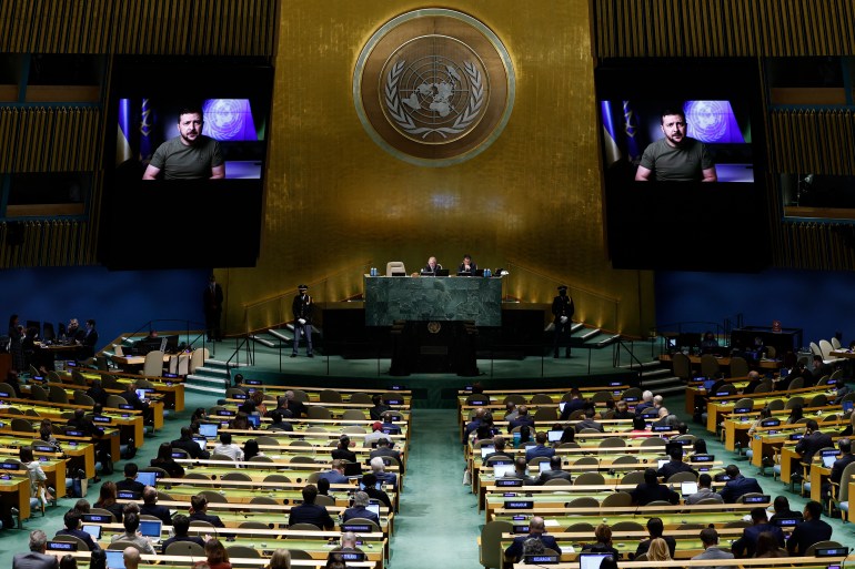 Delegates watch a pre-recorded speech by Ukrainian President Volodymyr Zelenskyy on two large screens on each side of the auditorium during the 77th session of the United Nations General Assembly.