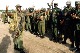 Ugandan soldiers sing and dance waving their assault rifles as they prepare to leave the eastern DR Congo town of Bunia April 25, 2003