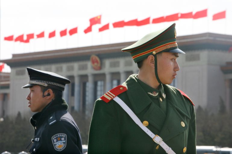 A Chinese paramilitary police (right) and a policeman (left) keep watch outside the Great Hall of the People in Beijing in 2008 [Claro Cortes/Reuters]