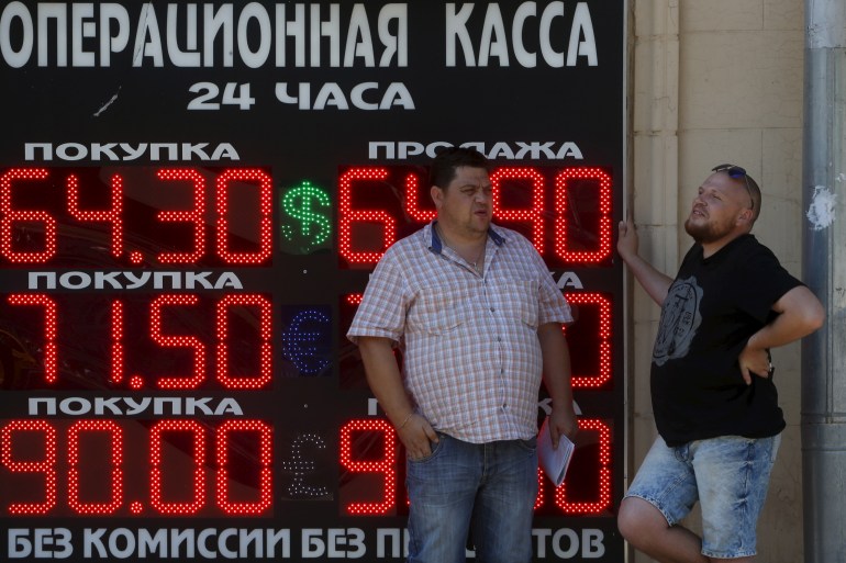Men stand next to a board showing currency exchange rates of the U.S. dollar, euro, and British pound (top-bottom) against the rouble in Moscow, Russia, August 12, 2015. The Russian rouble hit a six-month low on Wednesday, tracking down lower oil prices and ignoring a central bank statement saying that the devaluation of the Chinese yuan may ultimately benefit the rouble. REUTERS/Sergei Karpukhin