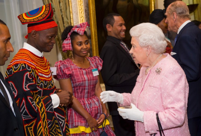 Queen Elizabeth II meets Africa Regional Winner of the Commonwealth Youth Awards Achaleke Christian Leke (L) and Caribbean Regional Winner Shamoy Hajare (C) at the annual Commonwealth Day reception at Marlborough House in London, March 14, 2016.