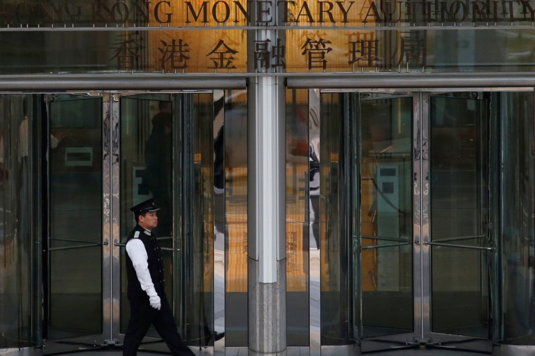 An attendant walks outside the entrance to Hong Kong Monetary Authority in Hong Kong, China.