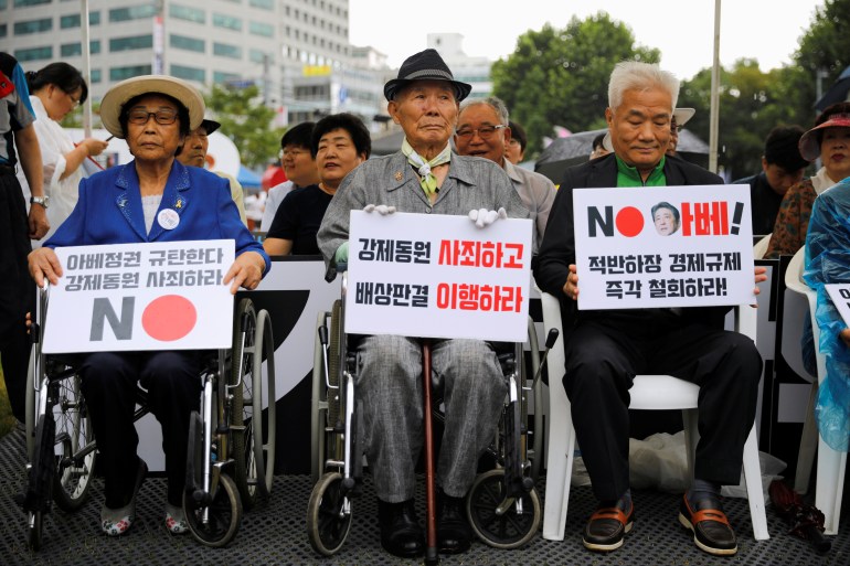 Japon sömürge döneminde savaş zamanında zorunlu çalıştırmanın kurbanı olan Lee Choon-shik, elinde şu yazılı bir pankart tutuyor "Zorla çalıştırma için özür dile ve tazminatı yerine getir" 15 Ağustos 2019, Seul, Güney Kore'deki Kurtuluş Günü'nde Japonya karşıtı bir protesto sırasında. 