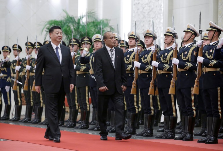 Kiribati President Taneti Maamau reviews Chinese troops with Xi Jinping at a welcoming ceremony in Beijing, China.