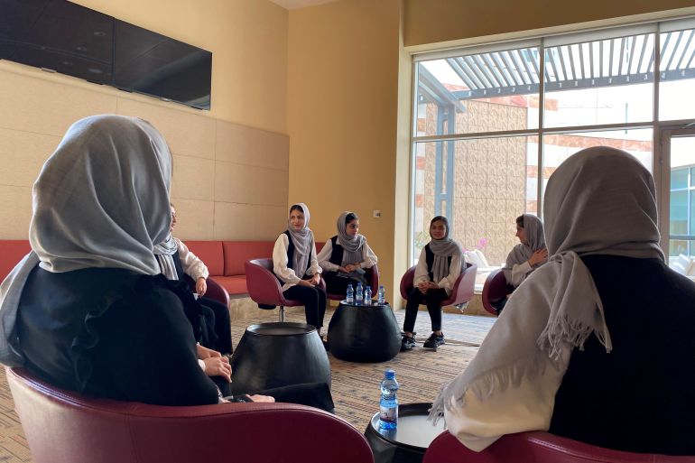 Members of an Afghan all-girls robotics team who were evacuated last week from Afghanistan speak to each other in Doha, Qatar