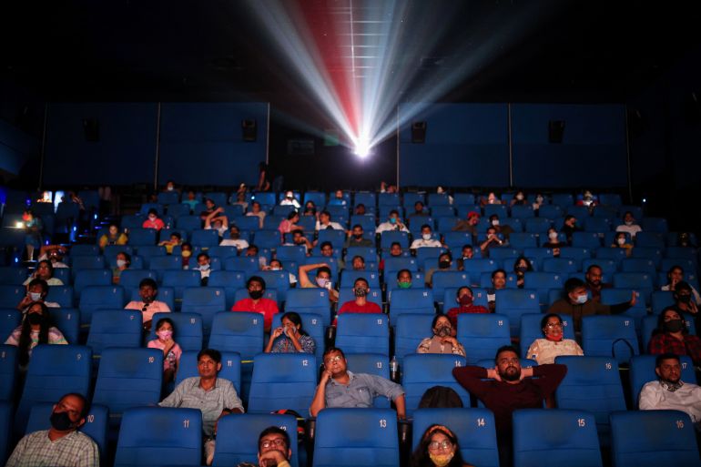 People watch a movie inside a cinema in Mumbai, India, November 5, 2021.