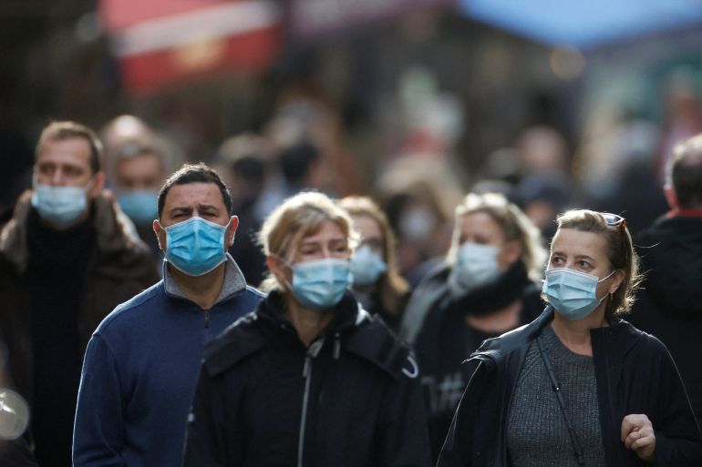People, wearing protective face masks, walk on the Mouffetard street