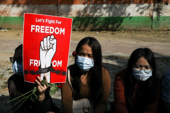 Myanmar citizens living in India hold a placard as they attend a protest, organised by pro-democracy supporters, against the military coup in Myanmar [File: Anushree Fadnavis/Reuters]