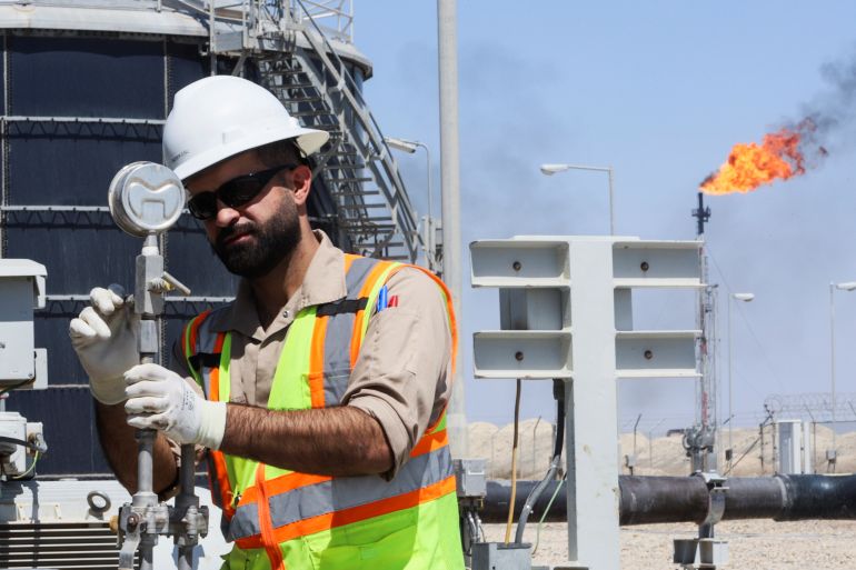 A worker checks and adjusts the valve of an oil pipeline at Majnoon oil field, near Basra, Iraq, March 27, 2022.