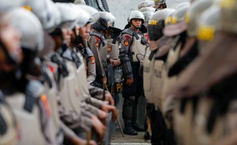 Police in riot gear stand guard during a protest in April 2022