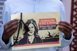 A journalist holds a placard with a picture of Al Jazeera reporter Shireen Abu Akleh, who was killed during an Israeli raid in the occupied West Bank area of Jenin, during a protest in Mogadishu, Somalia May 13, 2022.