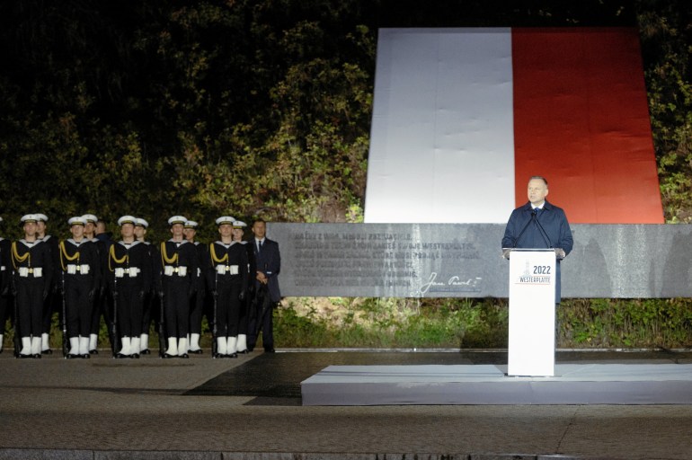 Polish President Andrzej Duda stands in front of World War 2memorial