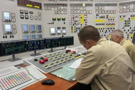 Two men work at a control panel at the Zaporizhzhia Nuclear Power Plant in Ukraine.