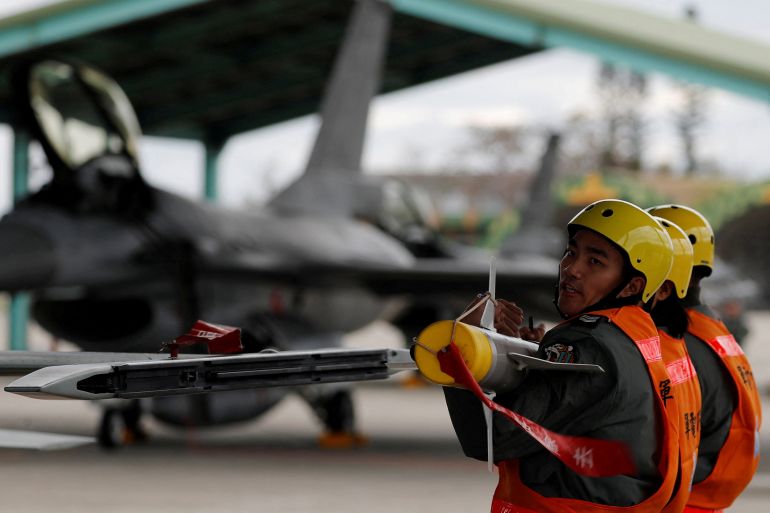Two members of Taiwan's armed forces move a an AIM-9 Sidewinder air-to-air missile ready to load it onto a fighter jet