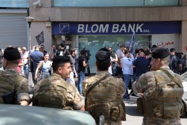 Members of the Lebanese army stand guard outside a Blom Bank branch in Beirut