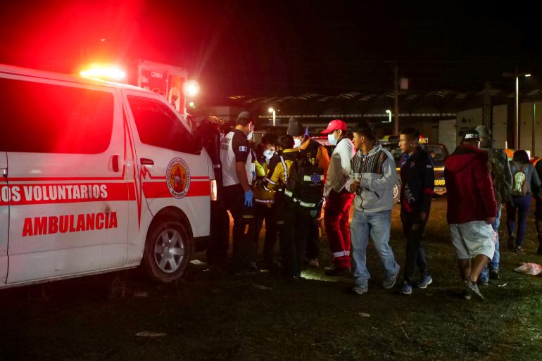 Paramedics and government officials stand at a scene of a deadly stampede in Guatemala that left at least 9 dead