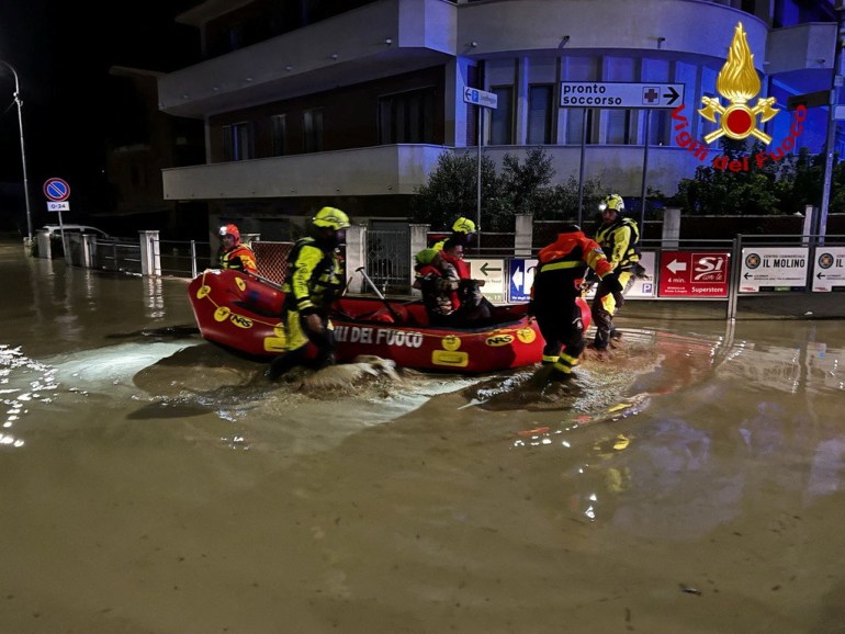 Rescue workers rescue people on a dinghy boat on a flooded street after heavy rains hit the east coast of Marche region in Senigallia, Italy
