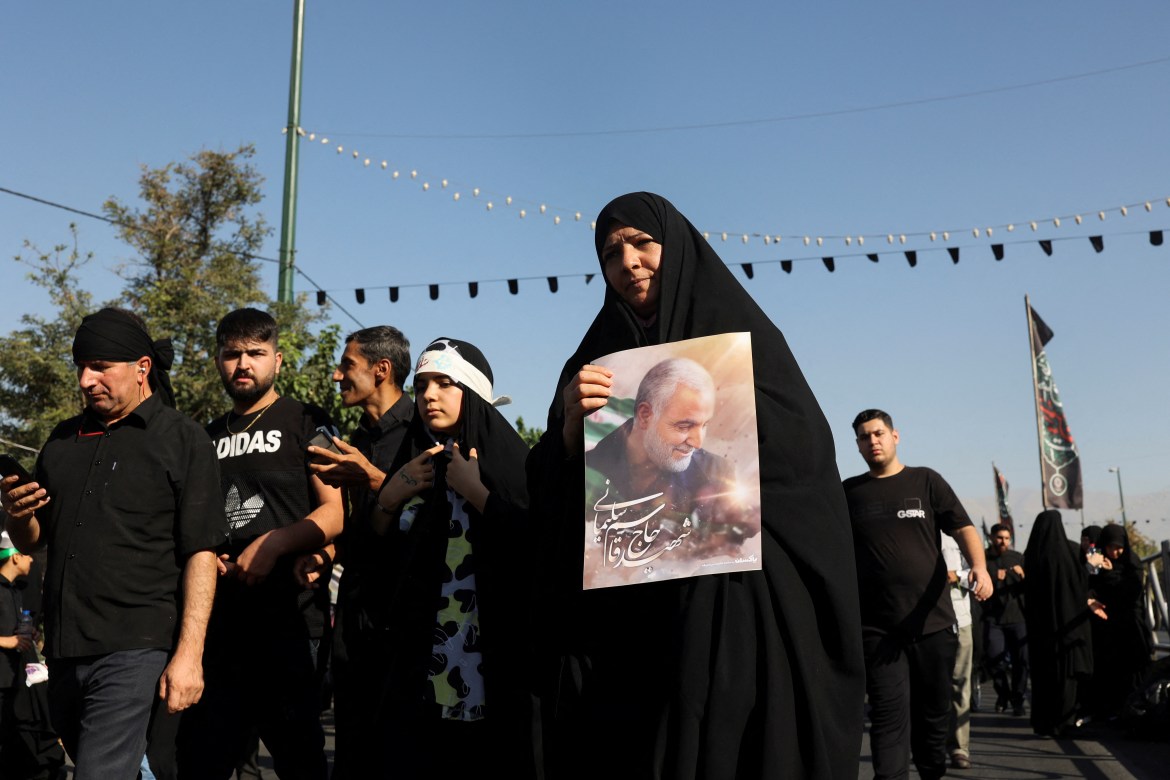 An Iranian woman carries a picture of the late Iran's Quds Force top commander Qassem Soleimani as they walk to commemorate Arbaeen in Tehran.