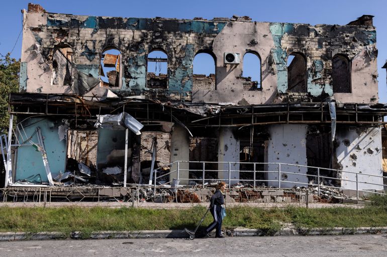 A woman walks past a destroyed building, as Russia's attack on Ukraine continues, in the town of Izium, recently liberated by Ukrainian Armed Forces, in Kharkiv region, Ukraine September 18, 2022