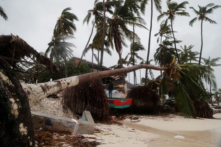 A man stands amid debris in the Dominican Republic, caused by Hurricane Fiona