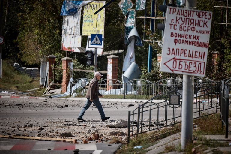 A man walks along a damaged street in the town of Kupiansk, recently liberated by the Ukrainian Armed Forces, amid Russia's attack on Ukraine, in Kharkiv region, Ukraine, in this handout picture released September 19, 2022. Ukrainian Presidential Press Service/Handout via REUTERS ATTENTION EDITORS - THIS IMAGE HAS BEEN SUPPLIED BY A THIRD PARTY.