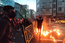People light a fire during a protest over the death of Mahsa Amini on the streets of Tehran, Iran.
