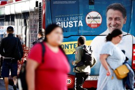 An election campaign poster of Giuseppe Conte, leader of Five Star Movement party, is displayed on a bus ahead of the snap election [File: Yara Nardi/Reuters]