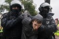 Russian law enforcement officers detain a person during a rally, after opposition activists called for street protests against the mobilisation of reservists.