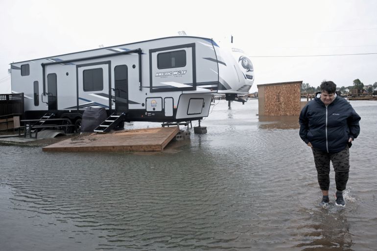 Cathy Simpkins of Moncton walks through flood waters to check her recreational vehicle trailer following the passing of Hurricane Fiona.
