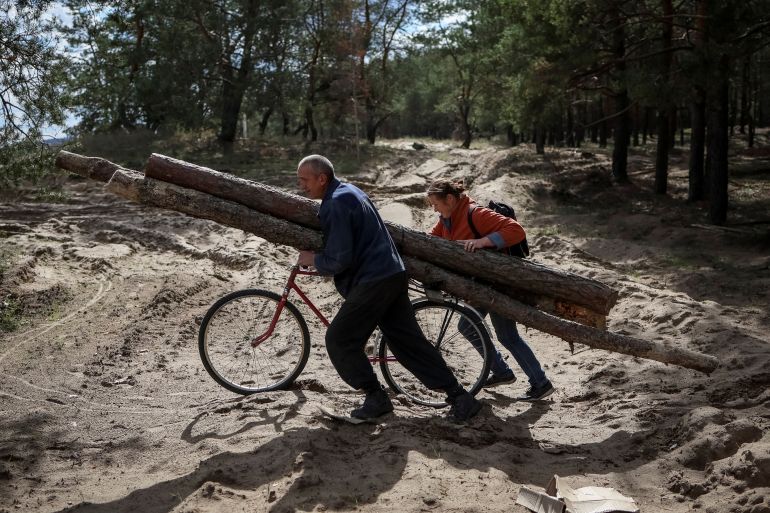 Local residents collect firewood from abandoned blindages of the Russian army to heat their homes, as they have no electricity,
