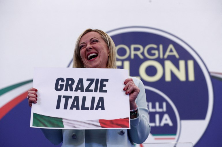 Giorgia Meloni holds up a sign reading 'Grazie Italy' (Thank you Italy) after a speech at her campaign headquarters