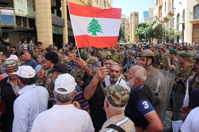 A demonstrator holds a Lebanese flag