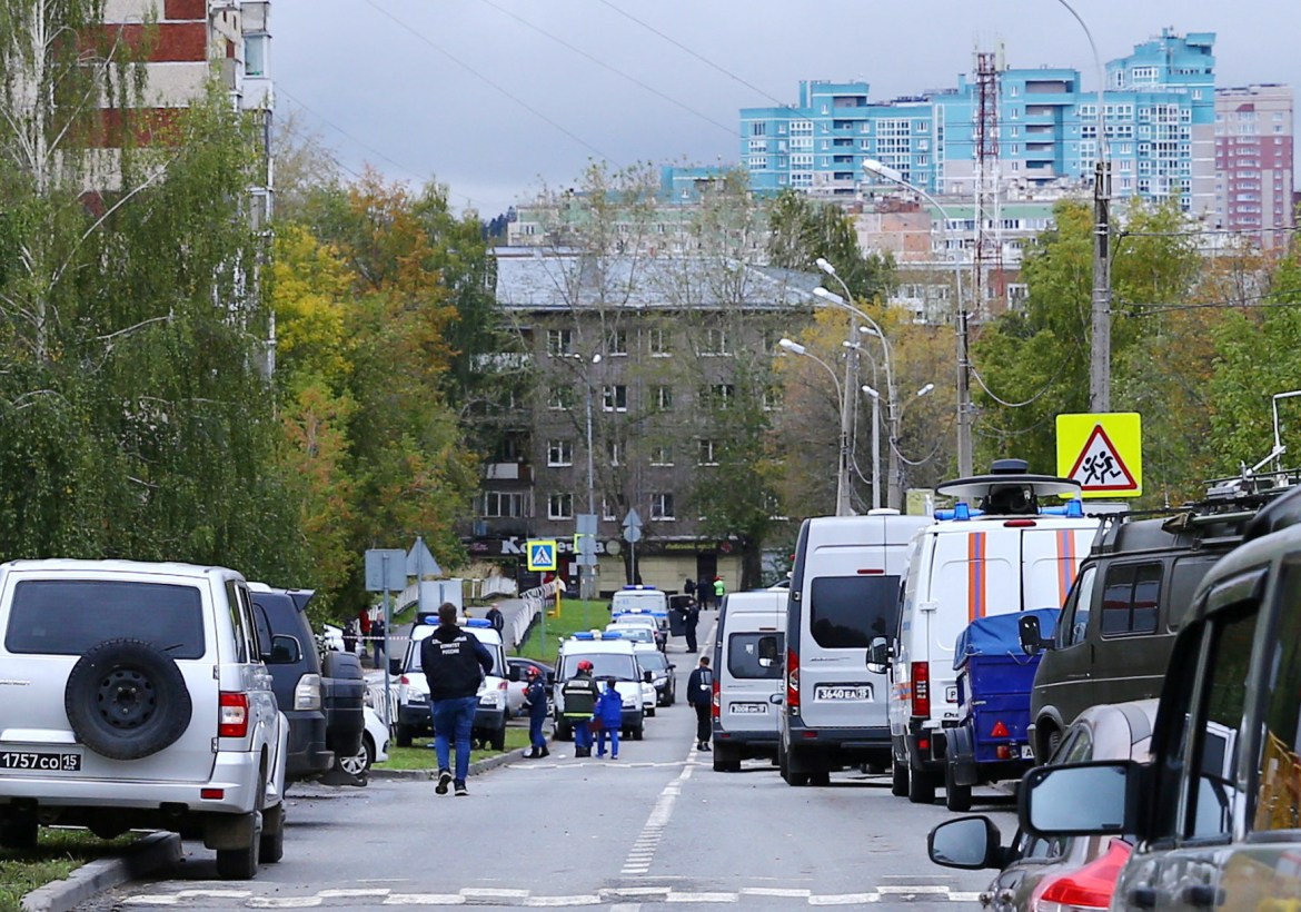 Police and members of emergency services work near the scene of a school shooting in Izhevsk, Russia