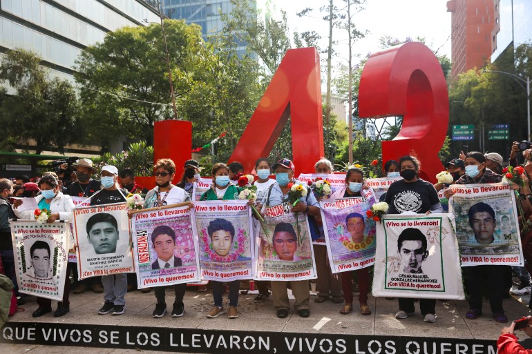 People hold banners during the protest in Mexico City
