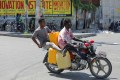 People ride a motorcycle with empty gasoline canisters