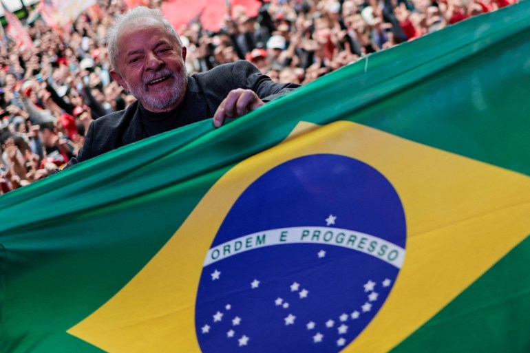 Former Brazilian President and presidential candidate Luiz Inacio Lula da Silva holds a Brazilian flag during a rally in Curitiba, Brazil, September 17, 2022.