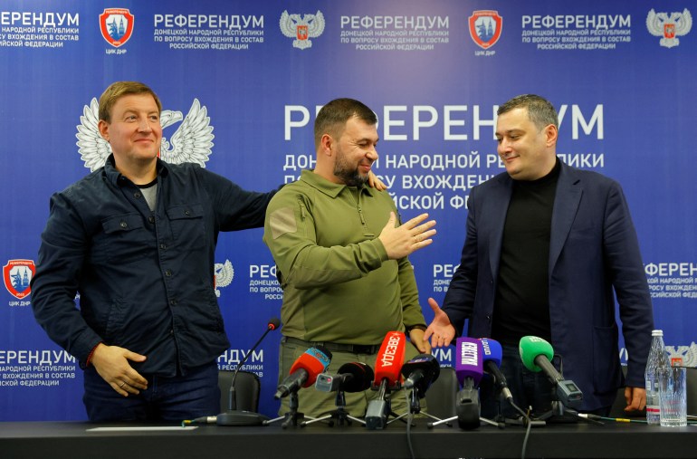 Head of the separatist self-proclaimed Donetsk People's Republic Denis Pushilin, Chairman of the Committee of Russia's State Duma on Information Policy, Information Technology and Communications Aleksandr Khinshtein and Secretary of the United Russia Party's General Council Andrey Turchak smile and shake hands with each other at a press conference on the referendum outcome