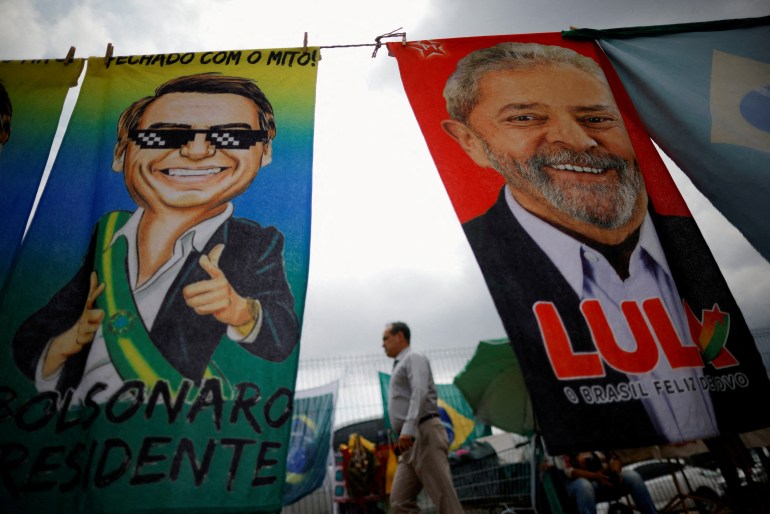 A man walks past presidential campaign materials depicting Brazil's former President Luiz Inacio Lula da Silva and and President Jair Bolsonaro in Brasilia, Brazil, September 23, 2022.
