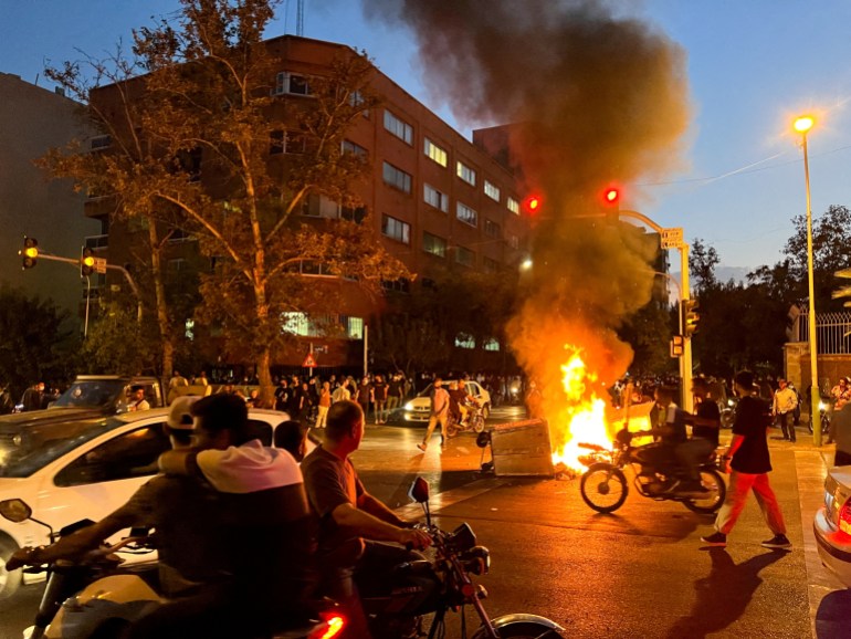 A police motorcycle burns during a protest over the death of Mahsa Amini, a woman who died after being arrested by the Islamic republic's "morality police", in Tehran, Iran September 19, 2022.
