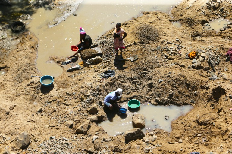 Small scale miners on a river bed on the outskirts of Harare, Wednesday, Sept. 9, 2020. Zimbabwe’s government says it has banned mining in its national parks, but an environmental group that had taken court action to stop the development of a coal mine in an elephant-rich park said on Wednesday that it will insist on “more than just words.” (AP Photo/Tsvangirayi Mukwazhi)