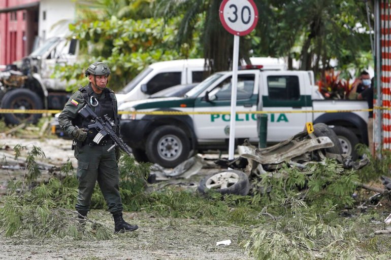 A police officer walks near the wreckage of a car bomb that exploded near a police station in Padilla, Cauca, Colombia, in February 2022 [File: Andres Gonzalez/AP]