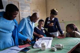 Health workers at a clinic in Malawi check records as they prepare to administer the world's first vaccine against malaria.